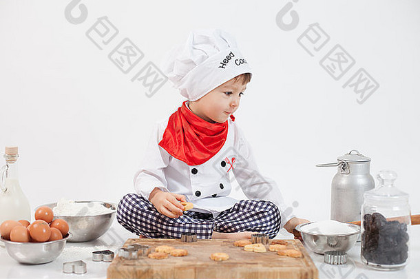 戴着厨师帽的小男孩正在准备饼干