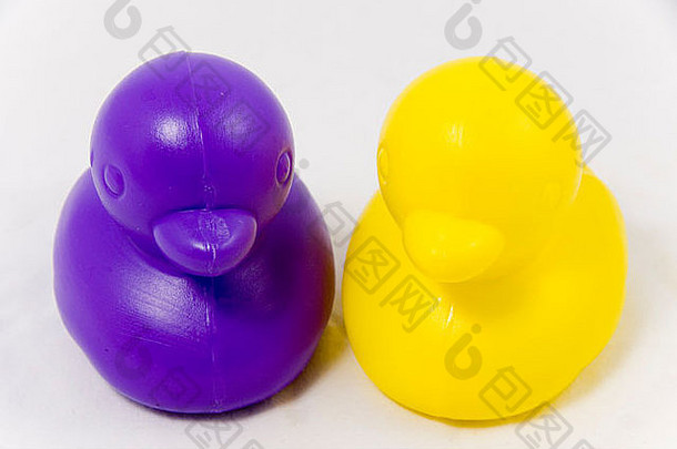 两个紫色和黄色相间的<strong>玩具</strong>鸭，白色的