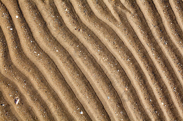 海滩上的黄金黄色沙滩俯视特写，罗纹干沙表面图案，波浪曲线对角线纹理，抽象曲线背景