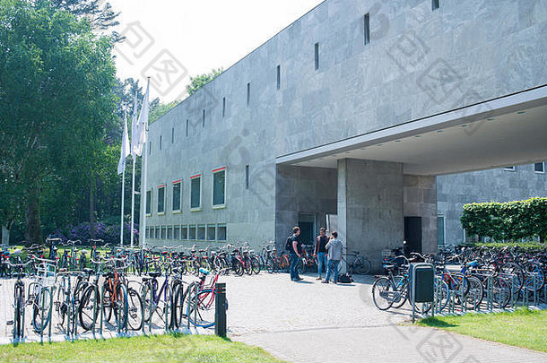 荷兰蒂尔堡大学校园周围的图片，显示人们在大学校园里散步和骑自行车