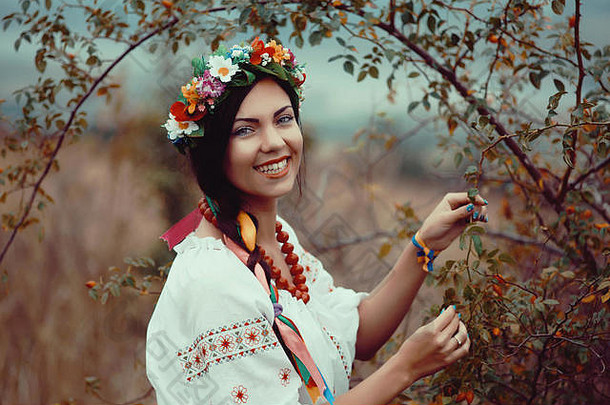 身着五彩缤纷的乌克兰传统服饰的美丽女子在田野里拥抱着自己，享受着夏日