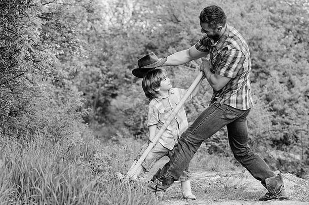 可爱的孩子自然有趣的牛仔爸爸找到珍宝男孩父亲铲珍宝精神冒险冒险狩猎珍宝助手花园