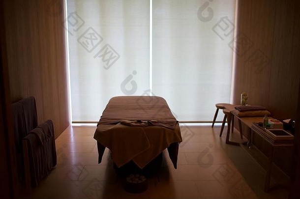 身体按摩床上用品的房间是空的。自然阳光从对面照射。为专业按摩治疗师和客户提供放松和放松