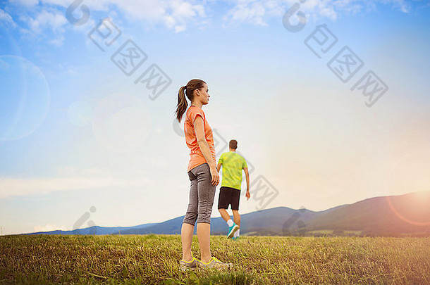 在日落时越野跑步。跑步夫妇在户外锻炼是健康生活方式的一部分。