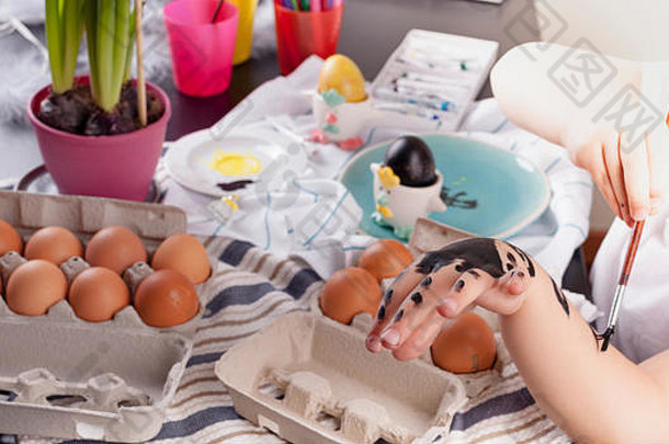 小女孩在家的厨房里画复活节彩蛋。春天的儿童和节日用品。快乐的孩子画画。拷贝空间