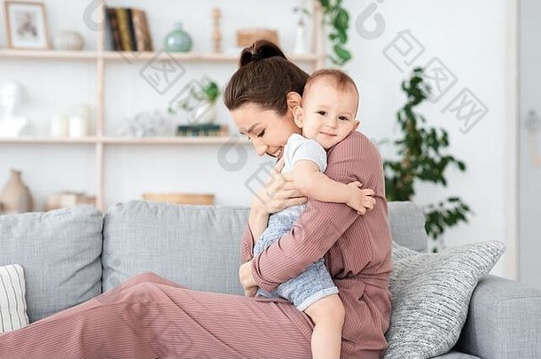 与婴儿的亲密关系。慈爱的妈妈在家里抱着她可爱的蹒跚学步的儿子