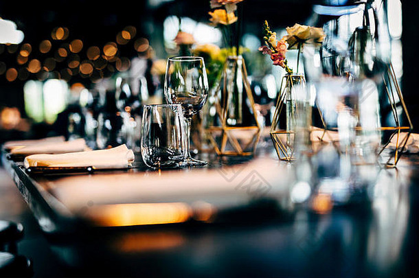 豪华的餐桌设置，用于精致的餐饮和玻璃器皿，美丽的模糊背景。参加活动、婚礼。为节日和圣诞节做准备