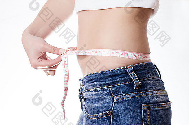 年轻的女人牛仔裤测量腰磁带