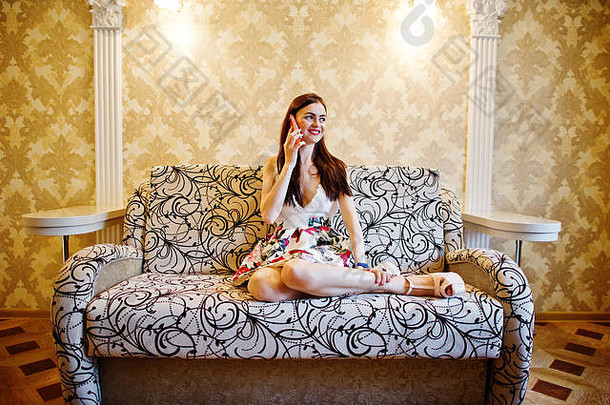 肖像有吸引力的年轻的<strong>女人</strong>会说话的电话坐着沙发