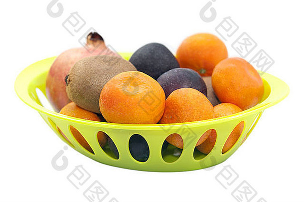 在白色背景上分离的绿色盘子中的柑橘、石榴、李子和猕猴桃