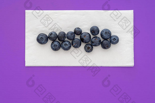 健康的超级食品蓝莓，白色餐巾，餐巾纸，紫色背景。使用copyspace。