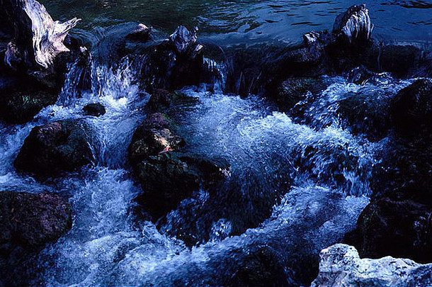 湍急的水流冲过黑色的岩石