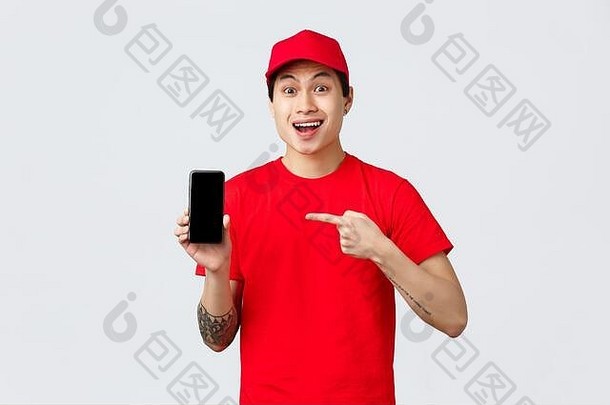 配送应用、网上购物和配送概念。惊讶的亚洲信使戴着红帽子，穿着t恤，指着手机应用程序