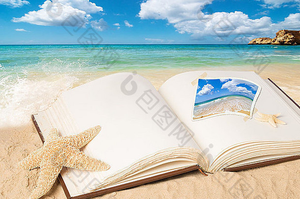 在夏季海滩上打开一本空白页的书，以获得复印空间