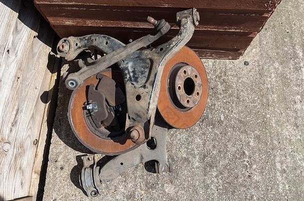 旧的生锈磨损的汽车零件、通风的制动盘、制动片和悬架臂（也称为叉骨或下臂）。这些零件将是可回收的金属。