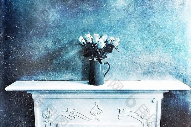 壁炉台上一瓶单色蓝色的玫瑰