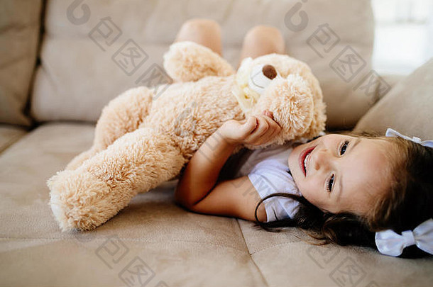 可爱的小女孩在玩泰迪熊