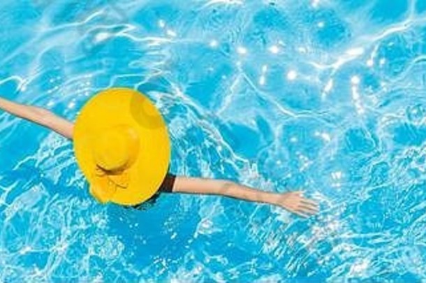 一名女子坐在游泳池里，打着长长的黄色太阳帽横幅