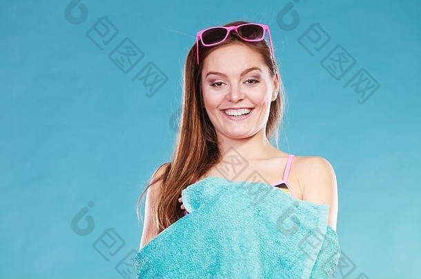 身着<strong>泳装</strong>、蓝色毛巾和太阳镜的快乐微笑的年轻<strong>女孩</strong>。暑假放松。