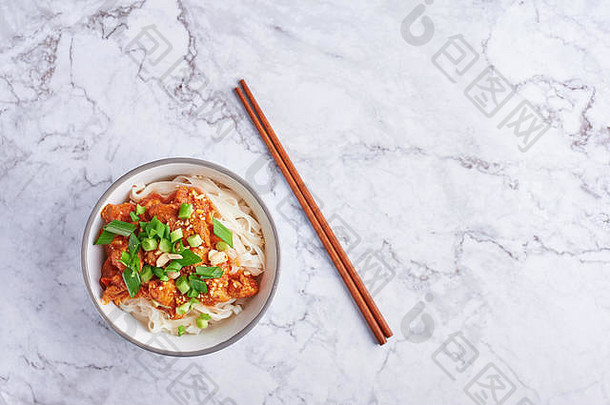 在白色大理石桌面上用筷子夹着面条。缅甸菜传统菜肴。缅甸食品。西红柿猪肉米粉。亚洲菜