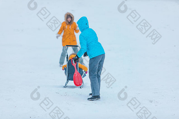 孩子雪橇滑动冬天山