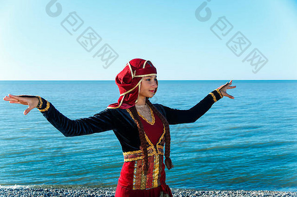 年轻女子跳舞格鲁吉亚民族服装海上户外夏日阳光明媚