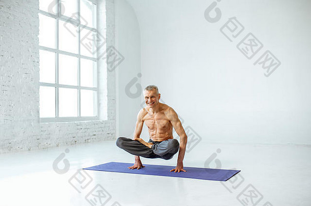 老人在白色工作室练习瑜伽