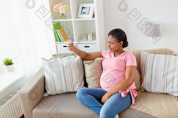 孕妇在家拍智能手机自拍