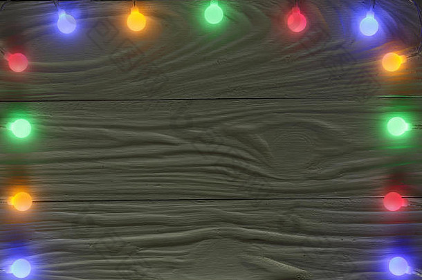 深色木质背景上的圣诞花环灯，文本的空间。俯视图