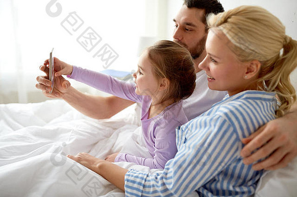 幸福家庭在家用智能手机自拍