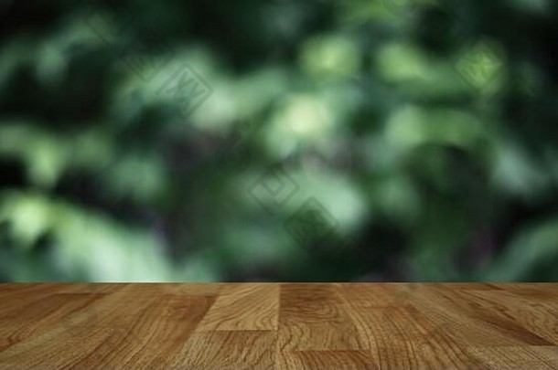 木桌背景以抽象模糊的柔和光线和清新的绿色自然为背景，模拟绿色生态环保产品展示。