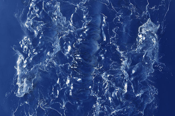 许多白色波浪在深蓝色液体中飞溅和旋转