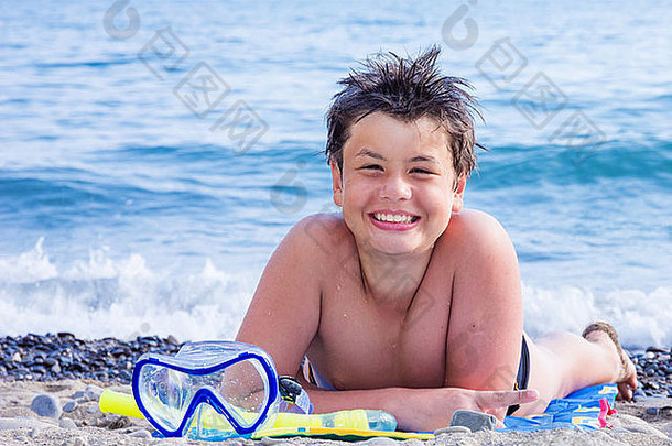海滩上戴着潜水面具的十二岁快乐欢笑的男孩