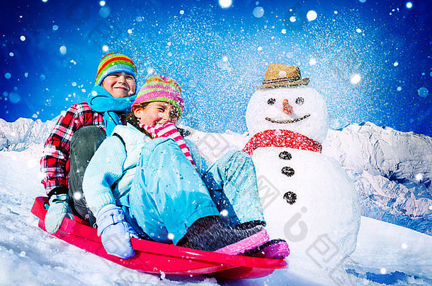 小女孩和男孩在户外滑雪和堆雪人
