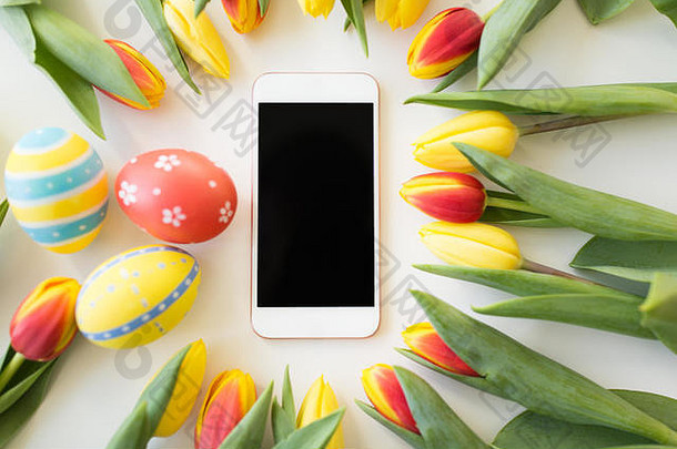 带复活节彩蛋和郁金香花的智能手机