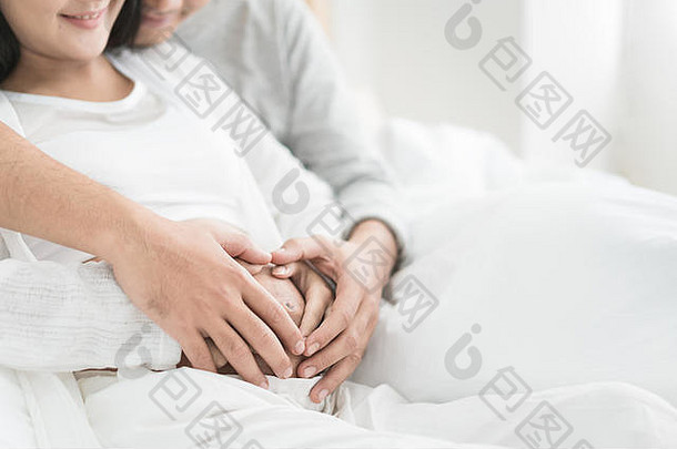 裁剪图像美丽的怀孕了女人英俊的丈夫拥抱肚子爱夫妇手使<strong>心怀</strong>孕了肚子