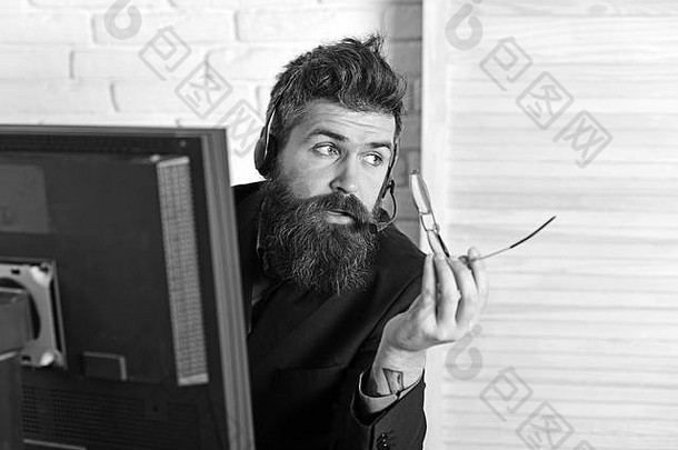 冷静而专业。留胡子的人在办公室工作。留着长胡子戴着耳机的男人。留胡子的公司电脑代表。呼叫中心