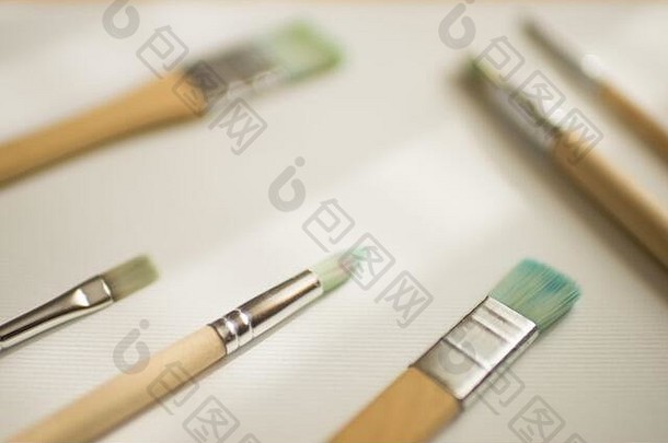 不同的画笔，用于在白色纹理纸上使用木制手柄进行绘画