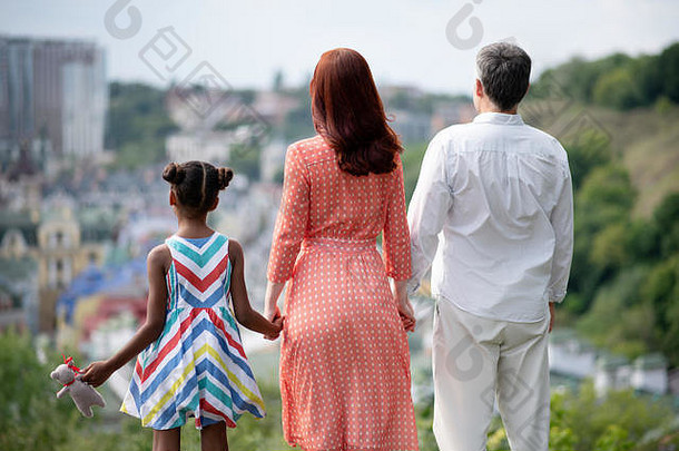 一家人站着，边走边欣赏迷人的城市景色