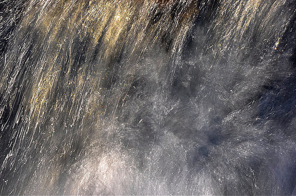 英国风景中，阳光照射在一条沼地小溪湍急水流上的抽象图像。