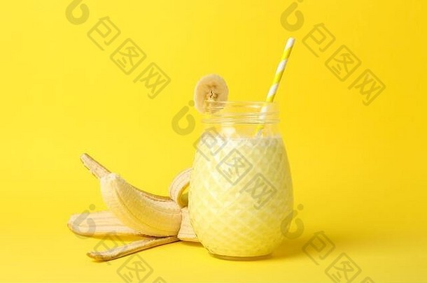 玻璃香蕉奶昔黄色的背景夏天喝