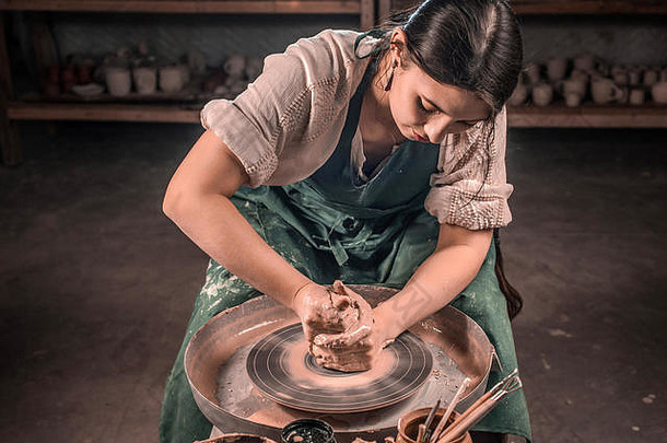 在陶轮上制作陶瓷壶的时尚工匠大师。手工制作的。
