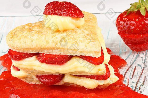 白色背景上，草莓酱上的心形草莓和奶油冻。为了一个甜蜜的情人节。