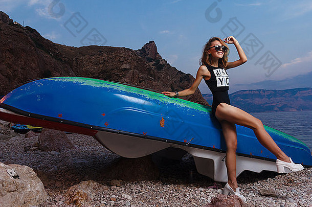 年轻少女乘坐双体船在日落海滩<strong>进行时</strong>尚拍摄