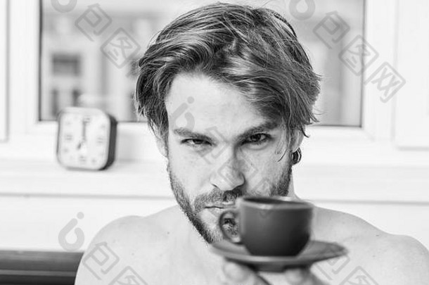 早上的第一件事。喝咖啡的最佳时间。每天早上喝咖啡。留着胡子的英俊男子端着一杯咖啡。帅哥帅哥享受新鲜的热咖啡。