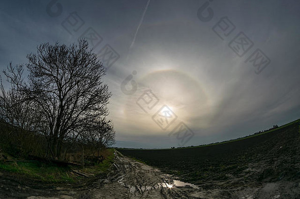 一个明亮的22度光环，在荷兰乡村上方有上切弧和parhelia