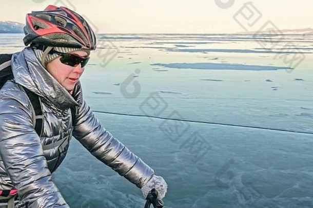 那个女人正在冰上骑自行车。自行车上的轮胎都有保险
