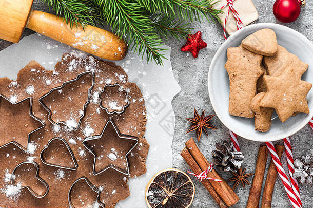 圣诞姜饼饼干，冷杉树枝，礼品盒和灰色混凝土背景上的装饰。顶视图。平铺