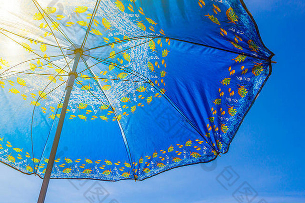 蓝天背景下的蓝色太阳伞特写镜头