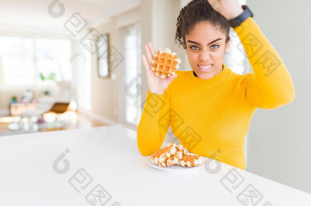 一位年轻的非洲裔美国妇女正在吃华夫饼比利时糕点，她愤怒地<strong>叫</strong>喊着，愤怒地举起手，疯狂地<strong>叫</strong>喊着